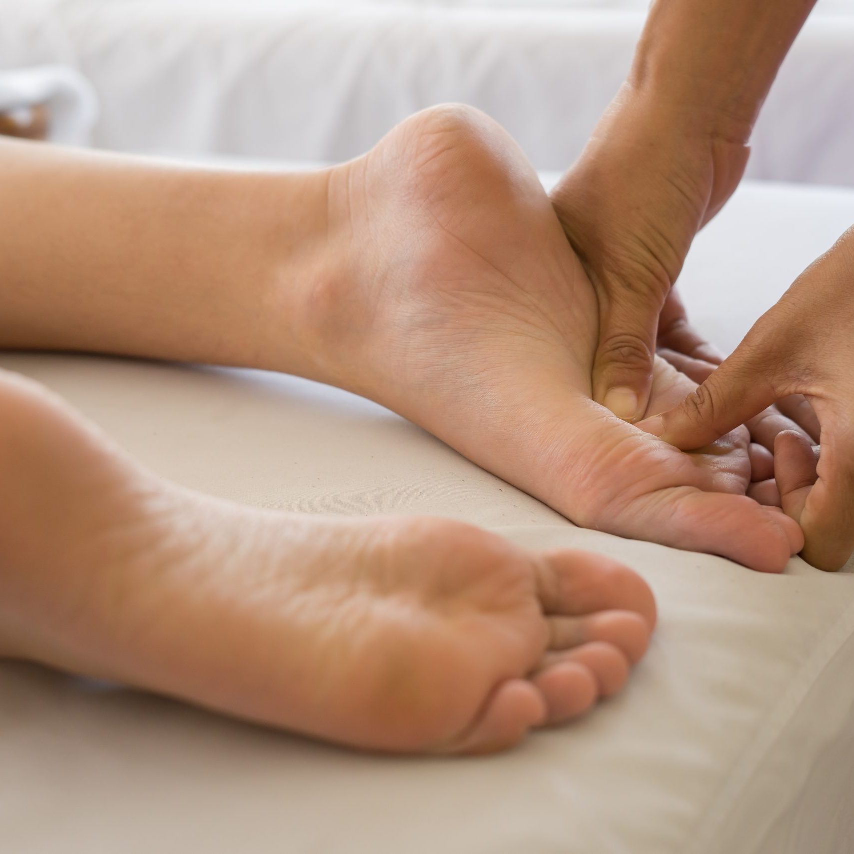 Close-up of woman doing foot massage at spa.