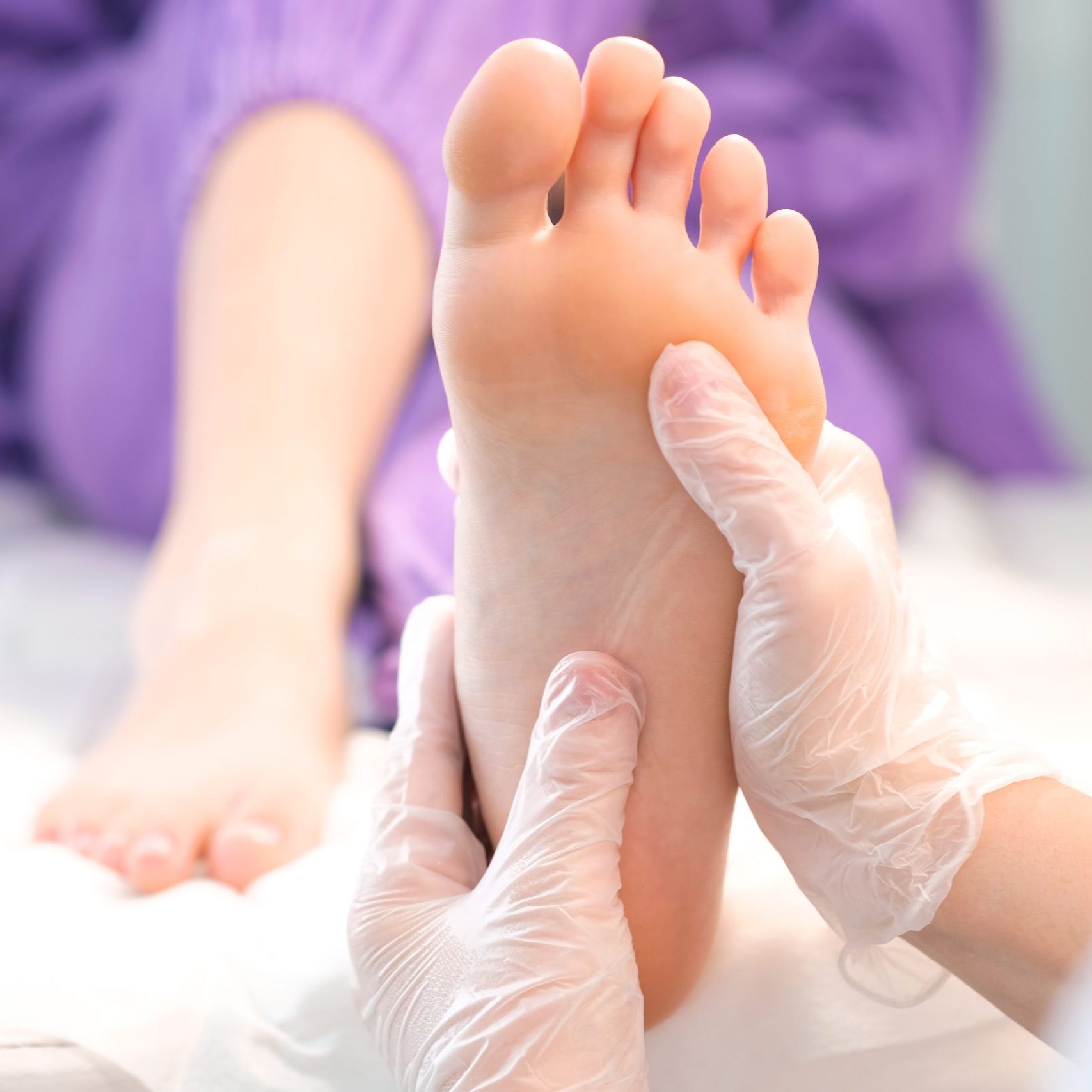 medical pedicure. foot massage with hands in transparent gloves.